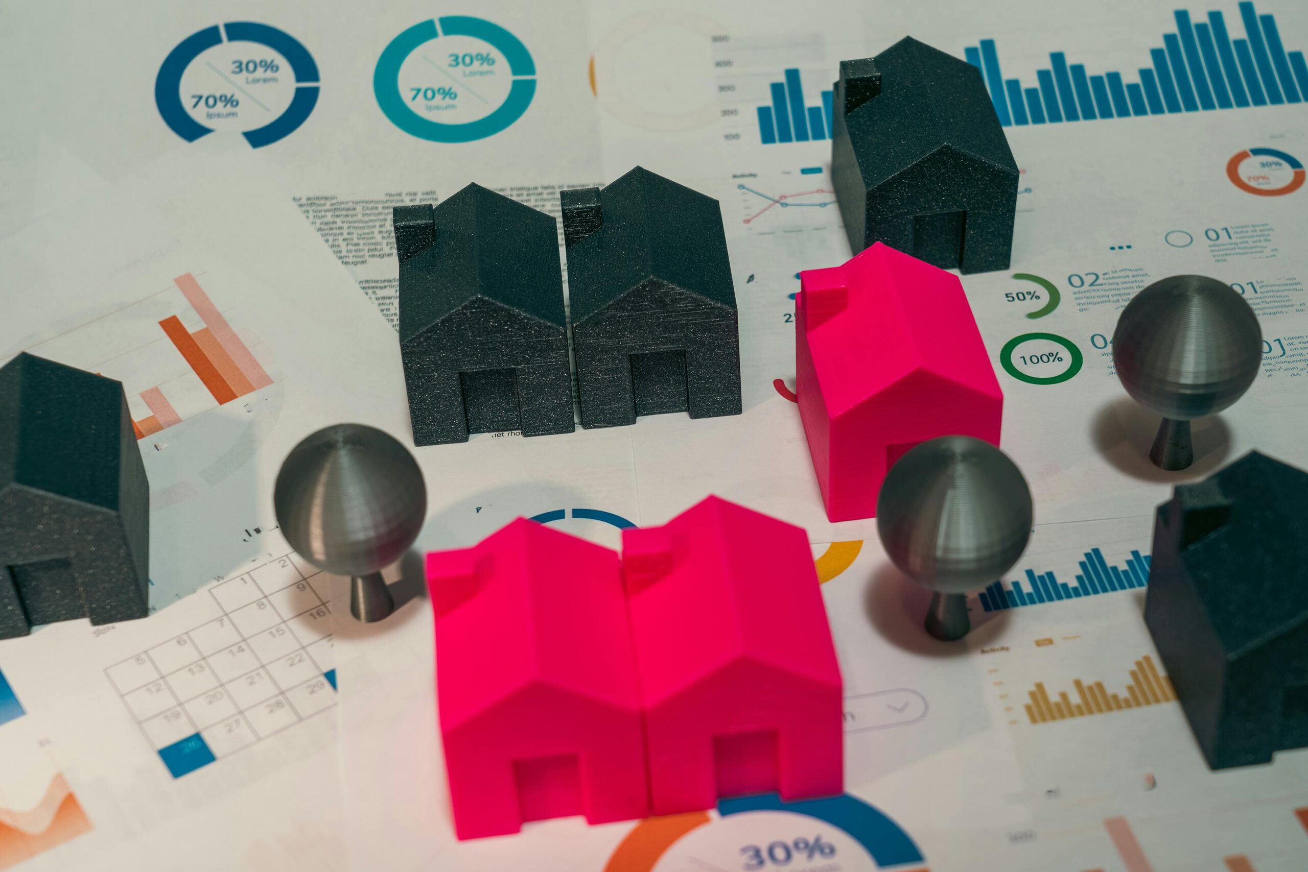 Colourful model houses on financial charts representing property investment and diversification © Pexels