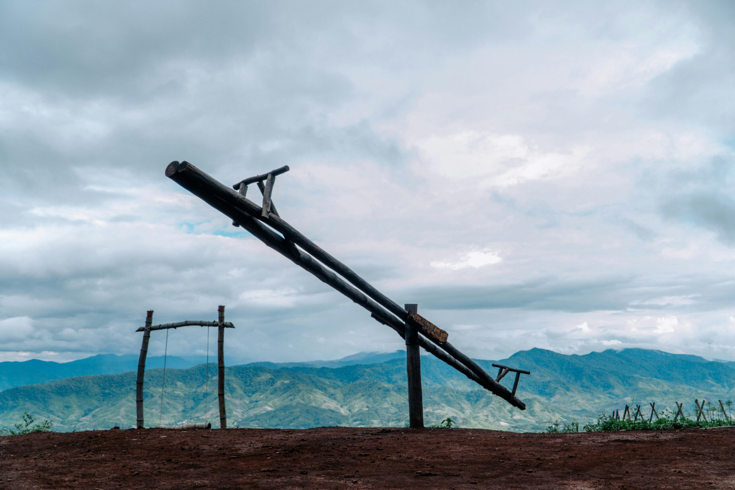 Wooden seesaw on a hilltop symbolising balance in financial planning