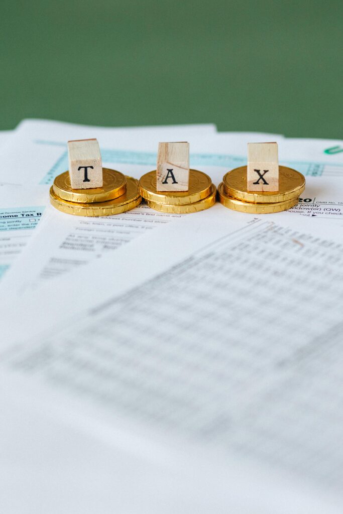 Gold coins stacked on financial documents representing pensions, inheritance tax and charitable estate planning © Pexels