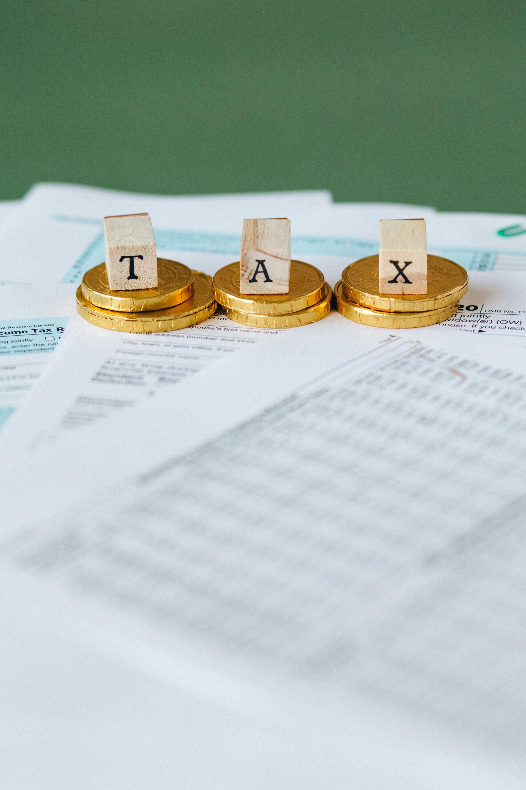 Gold coins stacked on financial documents representing pensions, inheritance tax and charitable estate planning © Pexels